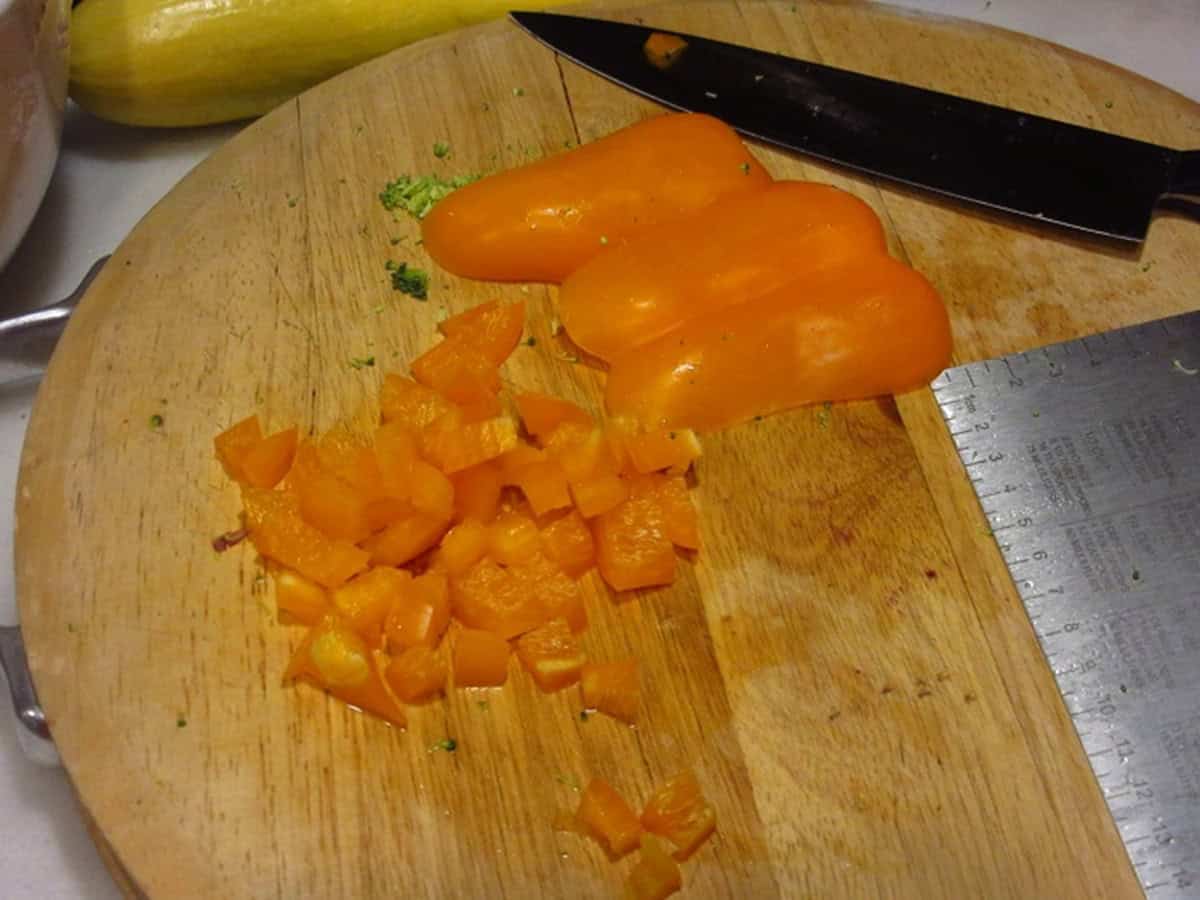 Diced orange bell peppers on a cutting board.