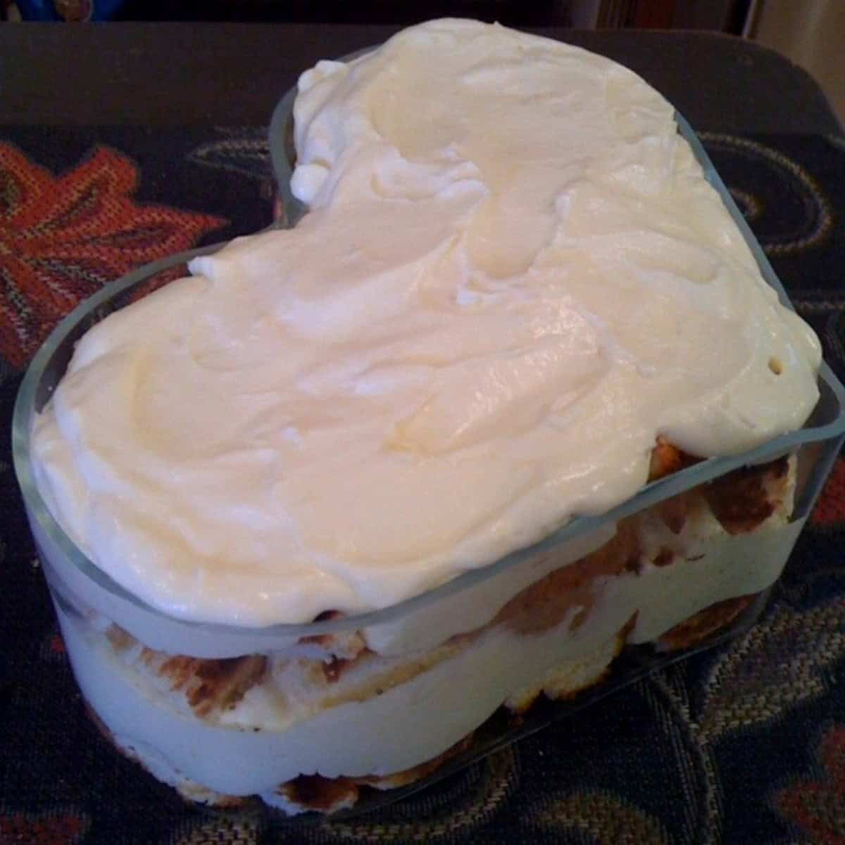 A heart-shaped glass bowl with layers of angel food cake and lemon curd whipped cream.