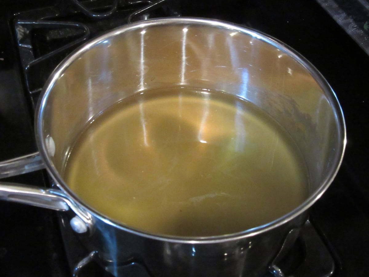Chicken broth in a saucepan on the stovetop.