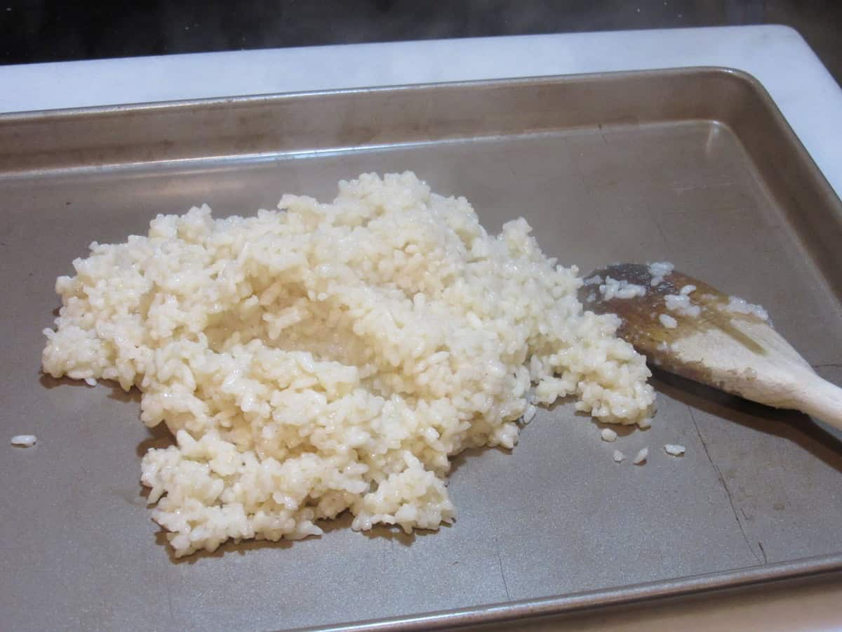 A blob of cooked rice on a baking sheet.