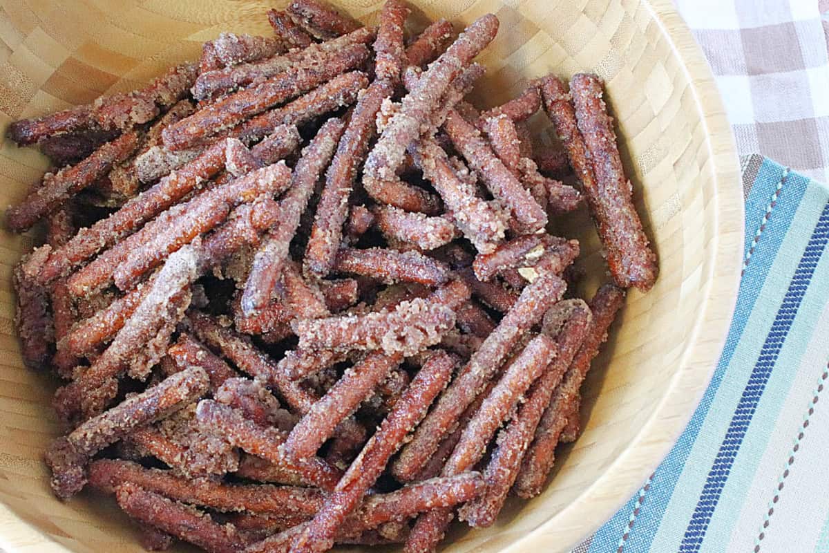 A wooden bowl filled with pretzel sticks covered in tons of cinnamon and sugar.