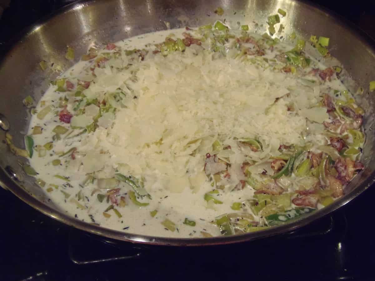 Creamy leek and bacon sauce in a large skillet.