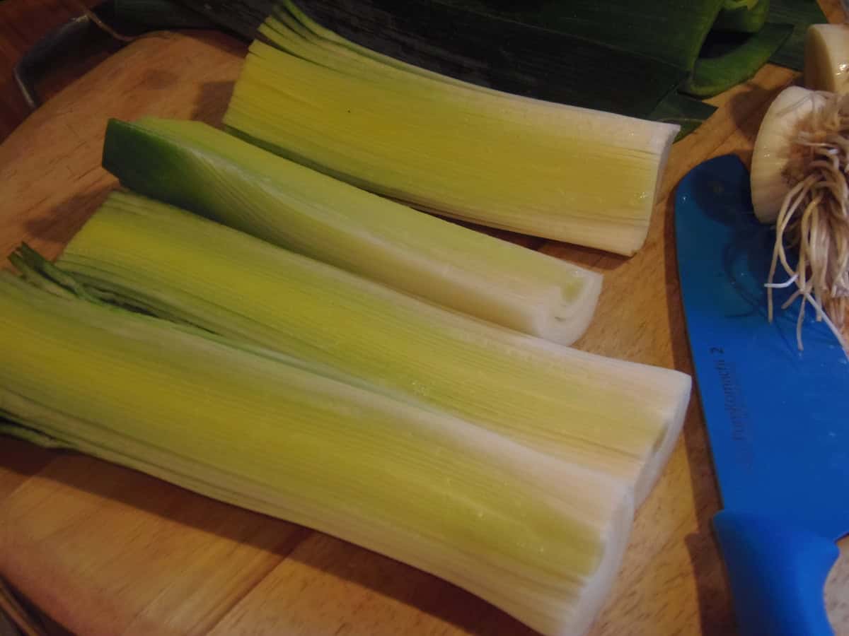 Preparing leeks on a wooden cutting board for a recipe.