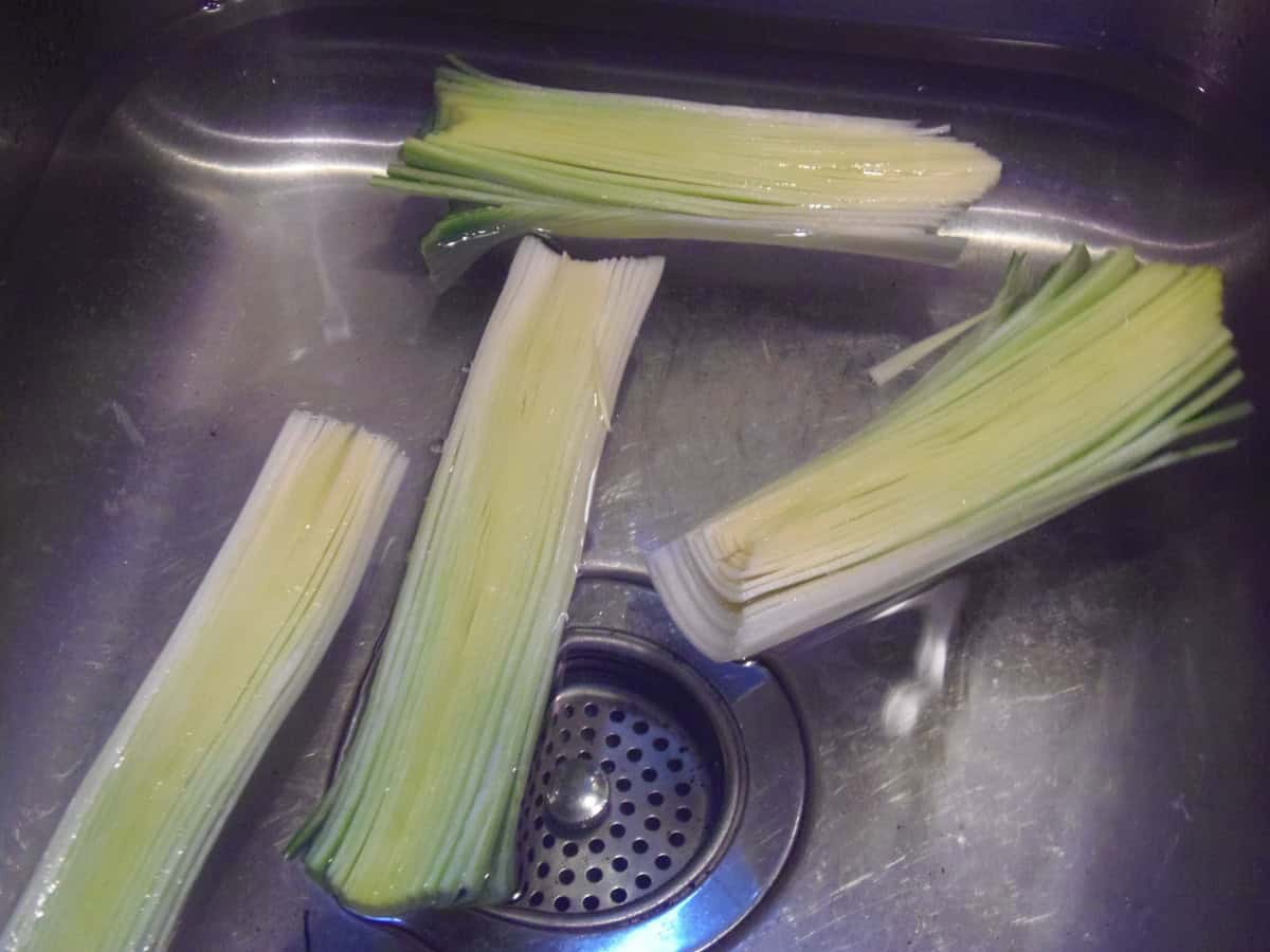 Sliced leeks in a sink of water for cleaning.