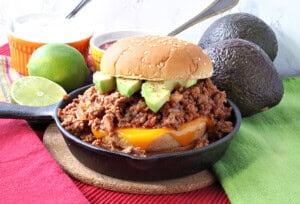 A salsa sloppy joe topped with avocado slices in a small cast iron skillet.