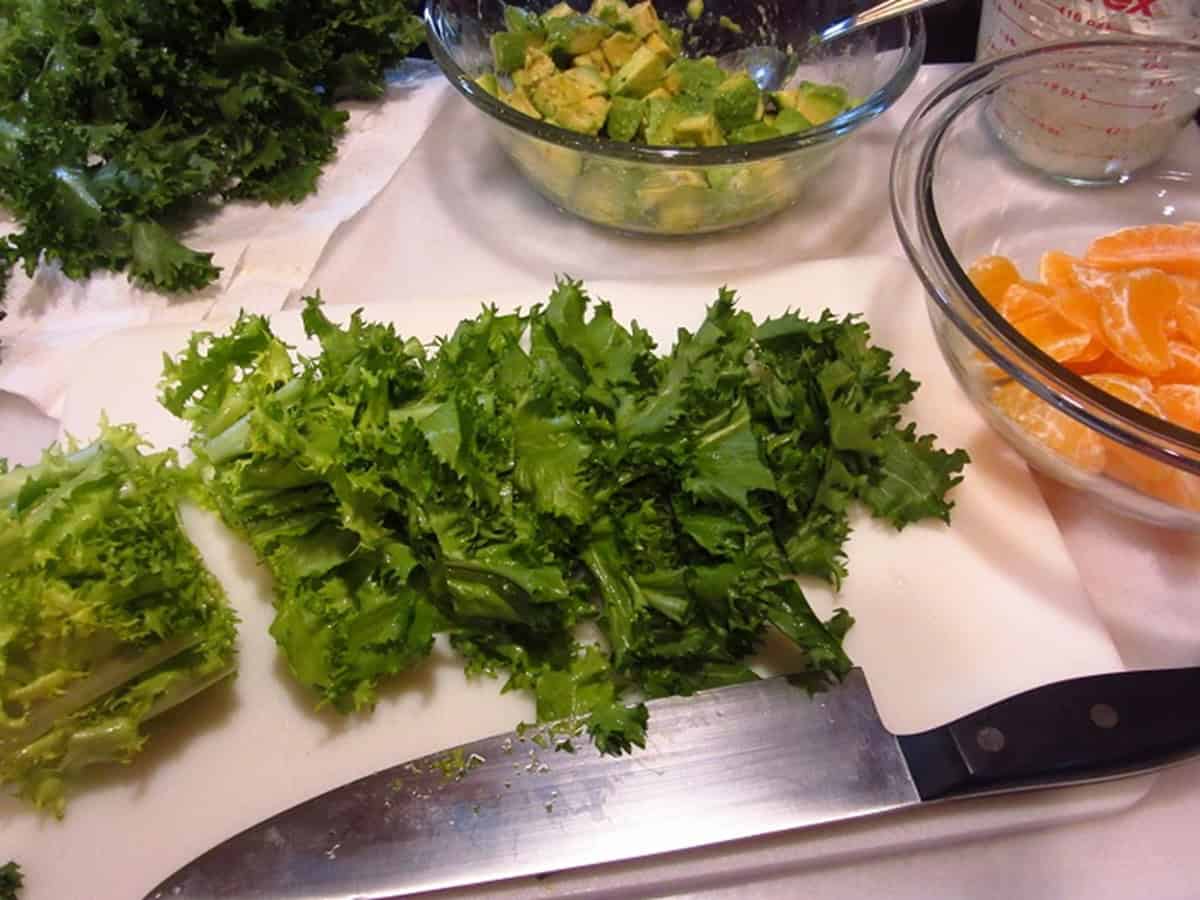 Chopped endive lettuce for making salad on a cutting board.