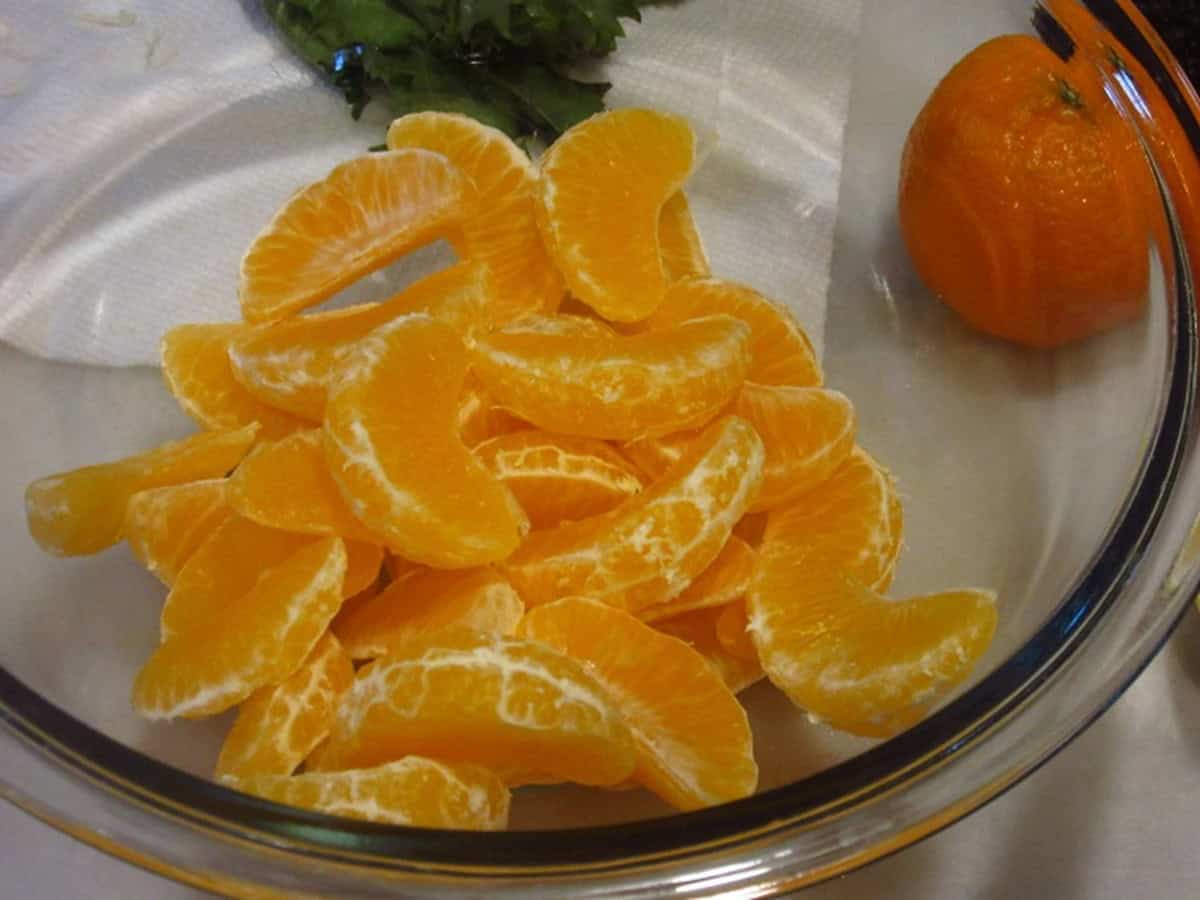 Fresh mandarin orange segments in a glass bowl.