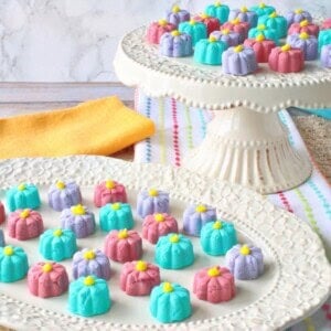 A pretty white platter and cake stand filled with colorful buttermint candy flowers for spring.