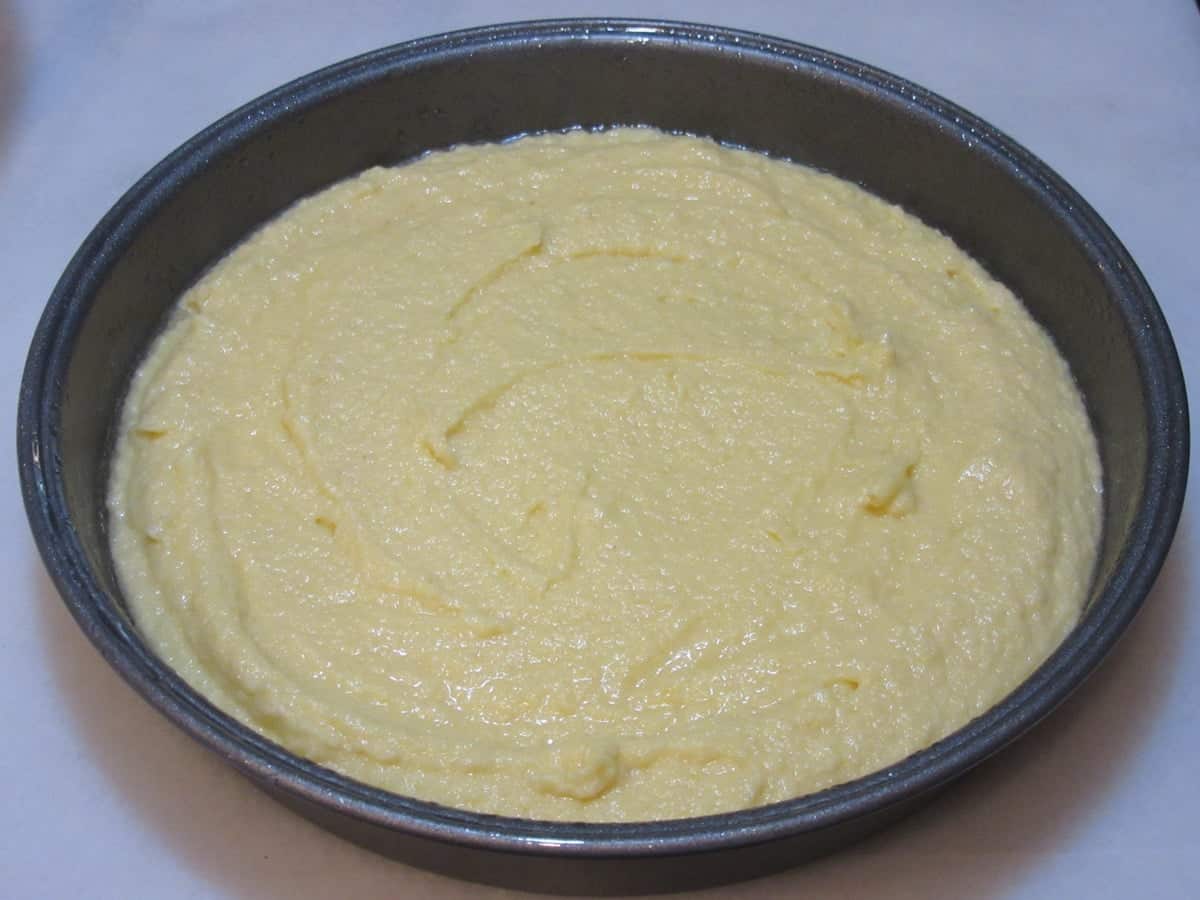 Almond cake batter before baking in a round cake pan.