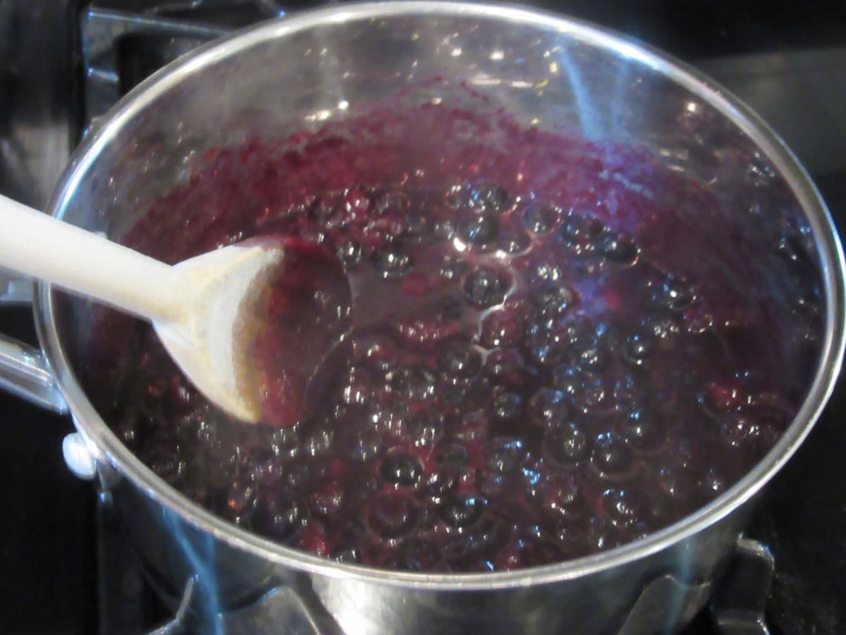 Fresh blueberries in a saucepan after being cooked down to a thick sauce.