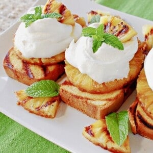Grilled pineapple and poundcake slices stacked and topped with whipped cream for a pretty dessert.