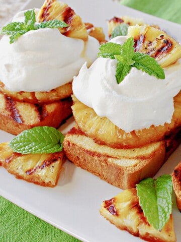 Grilled pineapple and poundcake slices stacked and topped with whipped cream for a pretty dessert.