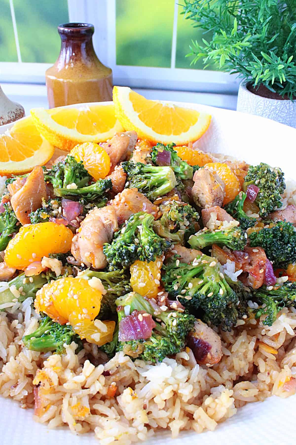 A colorful bowl of citrus ginger chicken with broccoli over rice.
