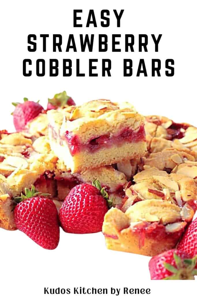 Some delicious looking stacked strawberry cobbler bars surrounded by fresh strawberries.