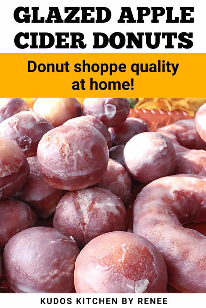 A delicious looking pile of glazed apple cider donut holes and donuts on a platter.
