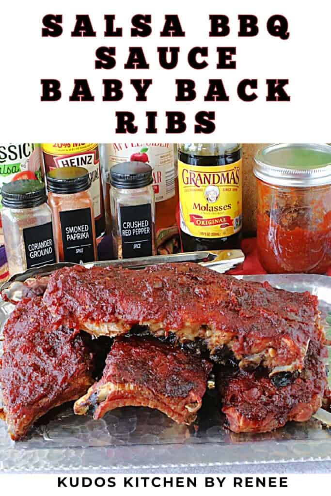 Four slabs of salsa BBQ sauce baby back ribs on a silver platter with jars of ingredients in the background.