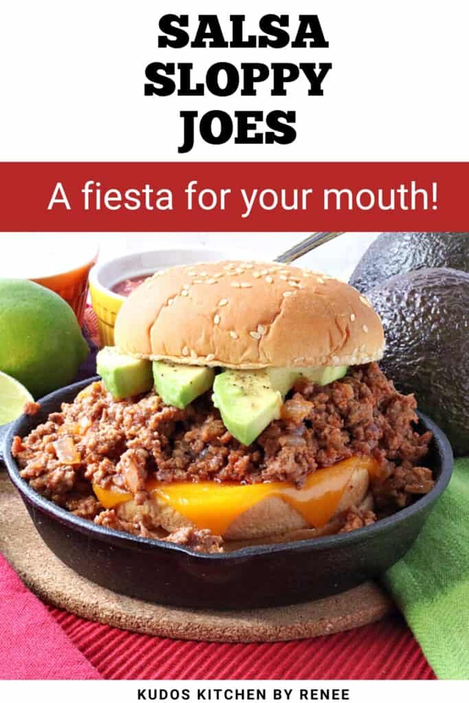 A salsa sloppy joe sandwich with melted cheese and sliced avocado on top in a small cast iron skillet.