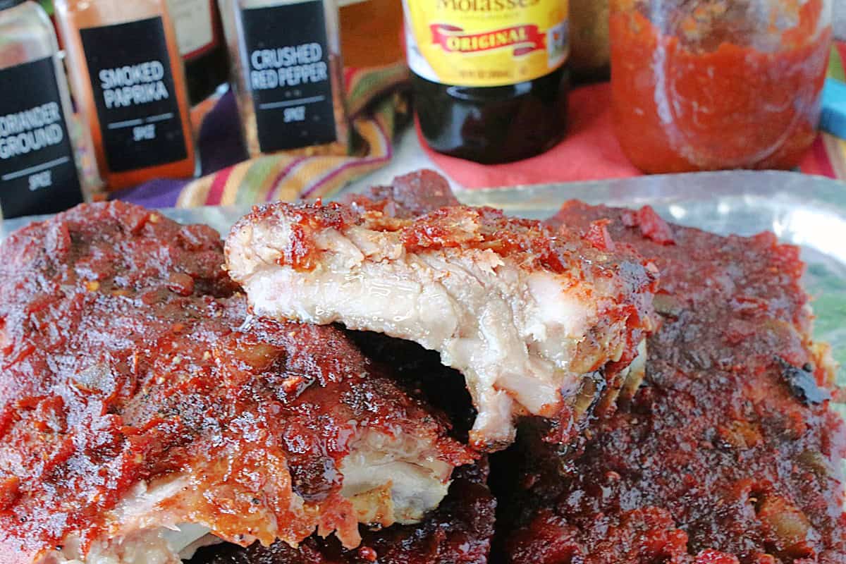 A stack of Salsa BBQ Ribs with the ingredients jars in the background.