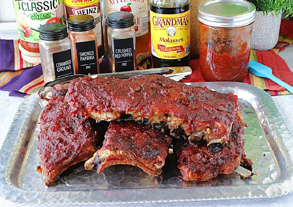 A silver platter topped with a stack of delicious roasted Salsa BBQ Sauce Baby Back Ribs.