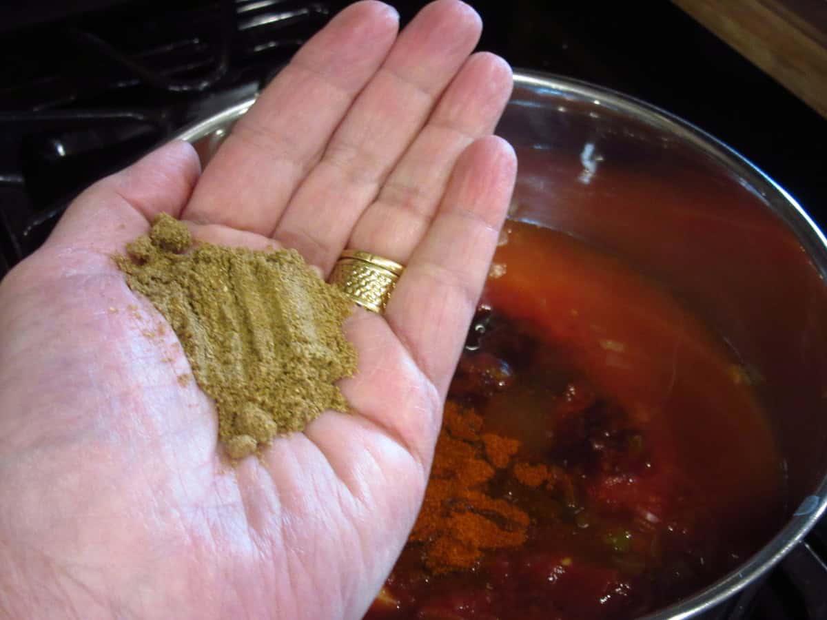 Ground coriander in the palm of a hand.