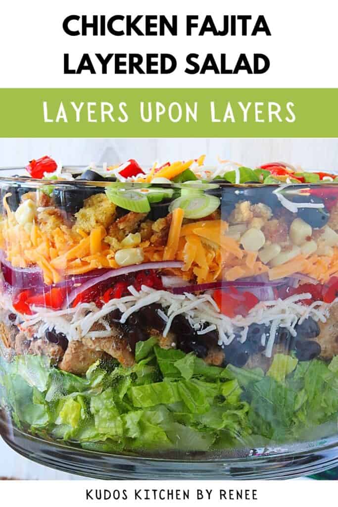 A colorful layered Mexican chicken fajita salad with cheese, olives, beans, and romaine.