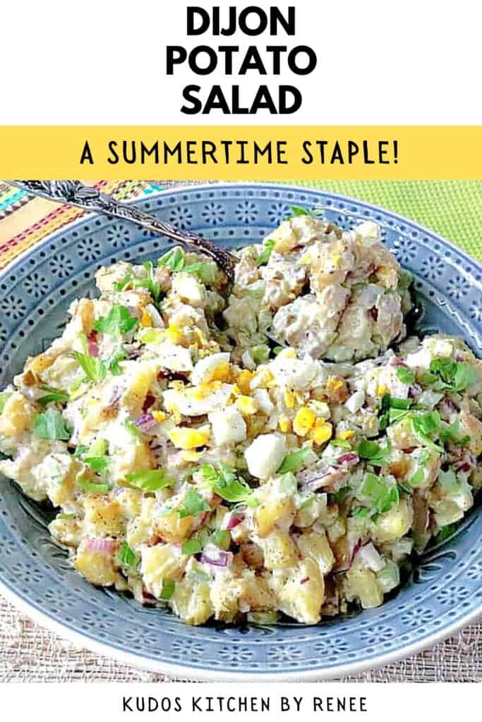 A creamy Dijon potato salad topped with eggs and celery leaves in a blue bowl.