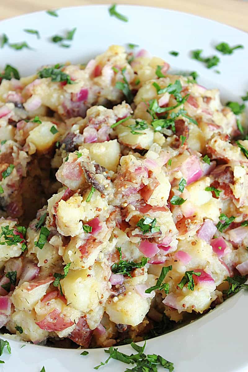 Delicious looking vinegar based German potato salad topped with fresh parsley.