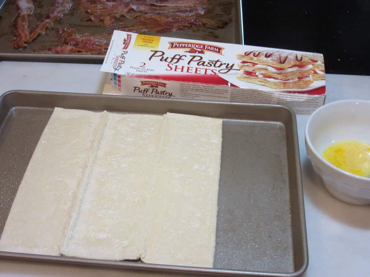 One sheet of puff pastry dough placed on an oiled baking sheet.