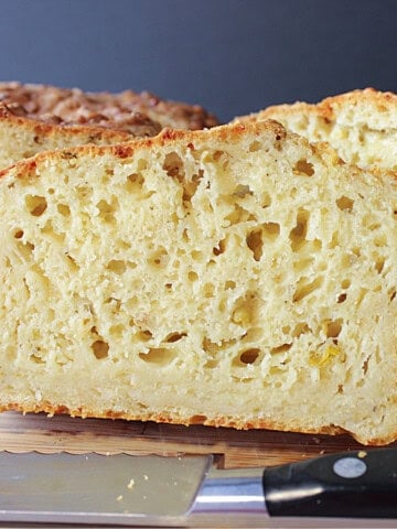 A dense looking slice of cheese jalapeno quick bread with plenty of air holes.