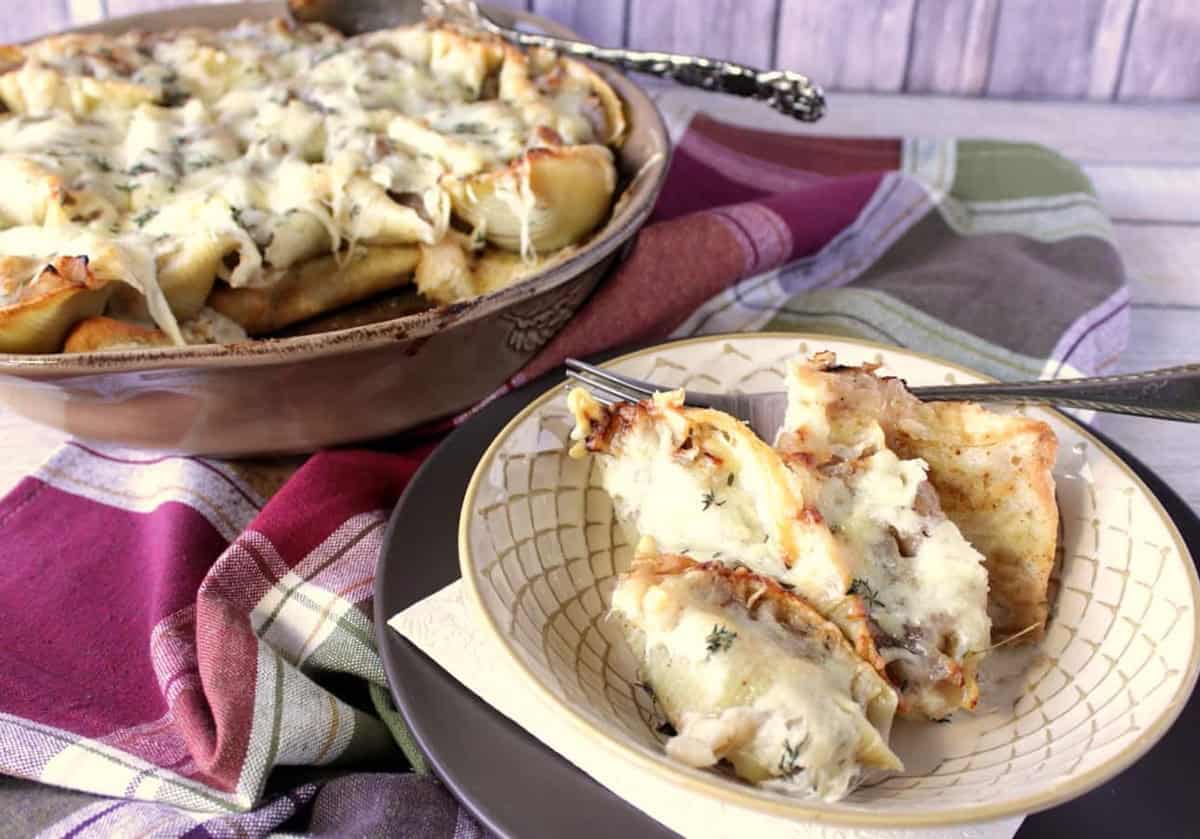Melted cheese covered French onion stuffed shells in a serving bowl and a casserole dish.