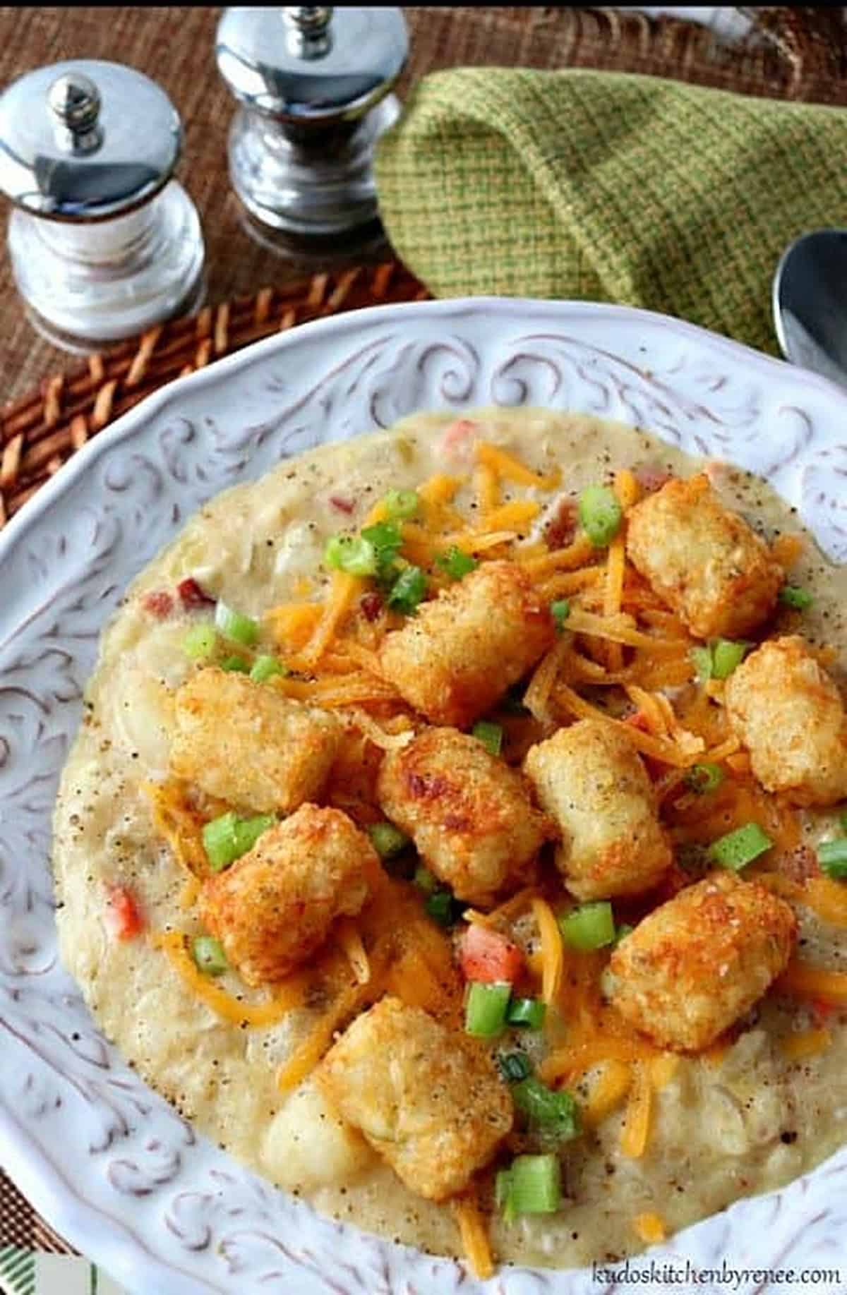 A delicious bowl of hearty tater tot chowder topped with tater tots, cheese, scallions and bacon.