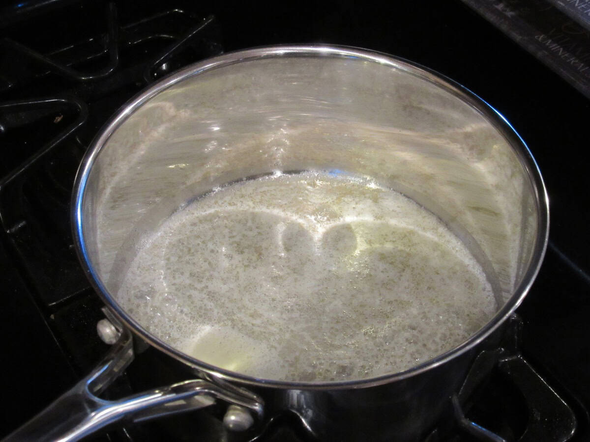 Melted butter in a saucepan on the stovetop.
