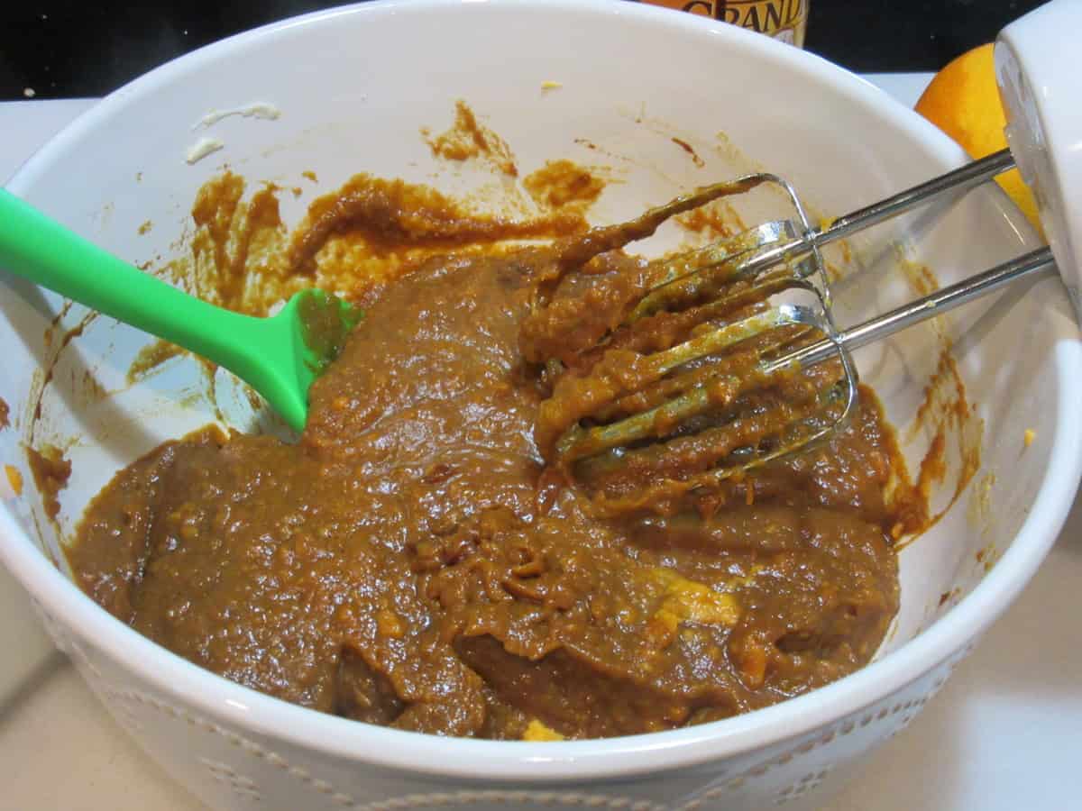 A hand blender in bowl blending the wet ingredients for making sweet potato cookies.