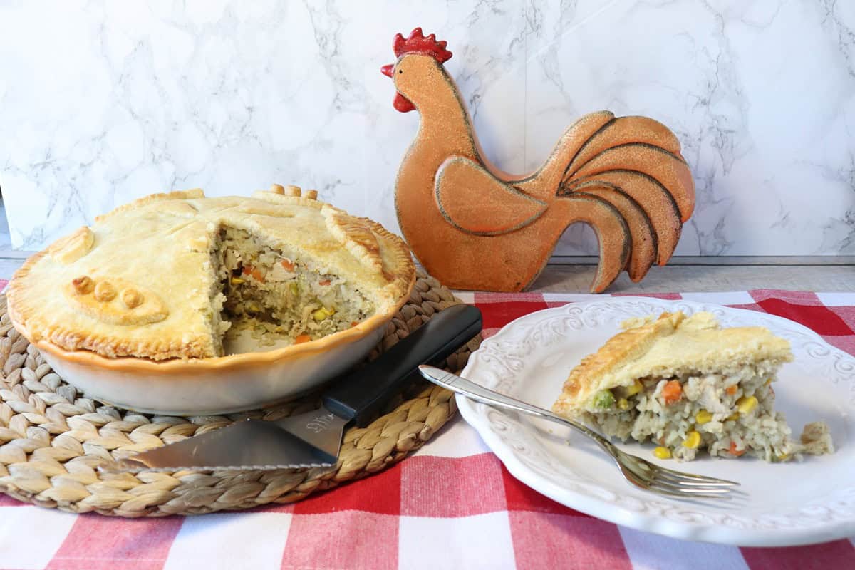 A chicken and rice pot pie with a slice taken out and the slice of chicken and rice pot pie on the side.