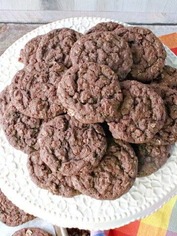 A white platter filled with a stack of delicious chocolate oatmeal cookies.