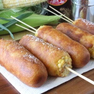 Pancake battered and fried golden corn on the cob fritters topped with powdered sugar.