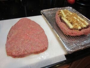 Two layers of uncooked meatloaf formed into cone shapes to make a rat loaf meatloaf.