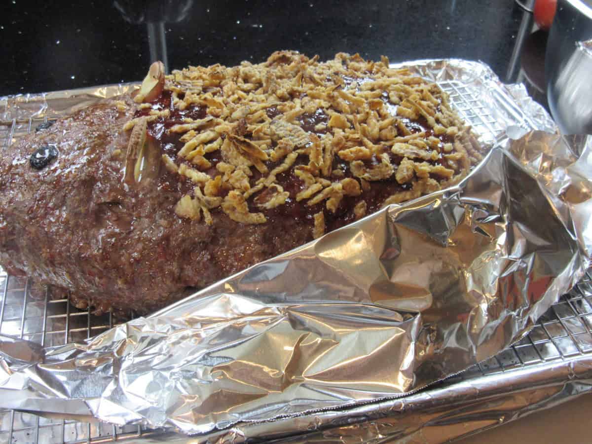 Aluminum foil covering the biscuit tail of a rat meatloaf so it doesn't burn.