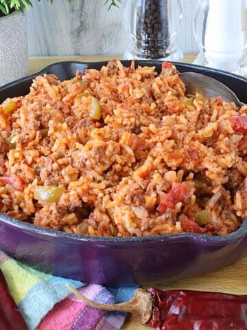 A budget family casserole of ground beef, rice, tomatoes and peppers in a skillet.