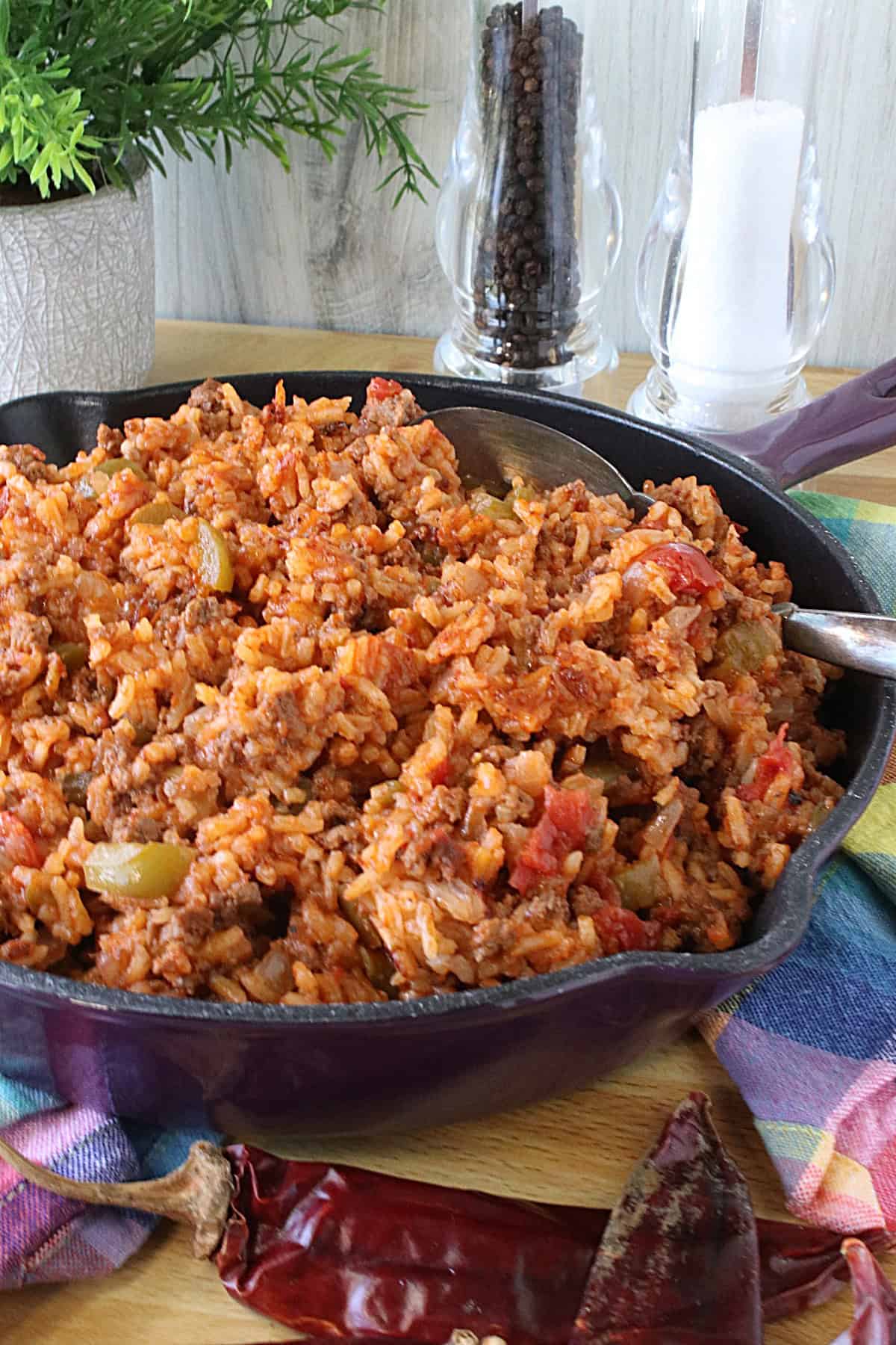 A family dinner of Texas Hash with rice and ground beef in a purple skillet.