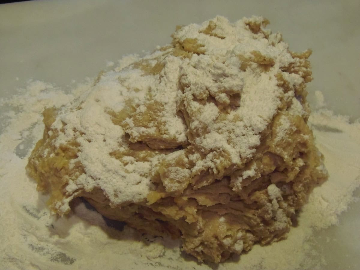 A shaggy sweet potato cake donut dough with flour on top.