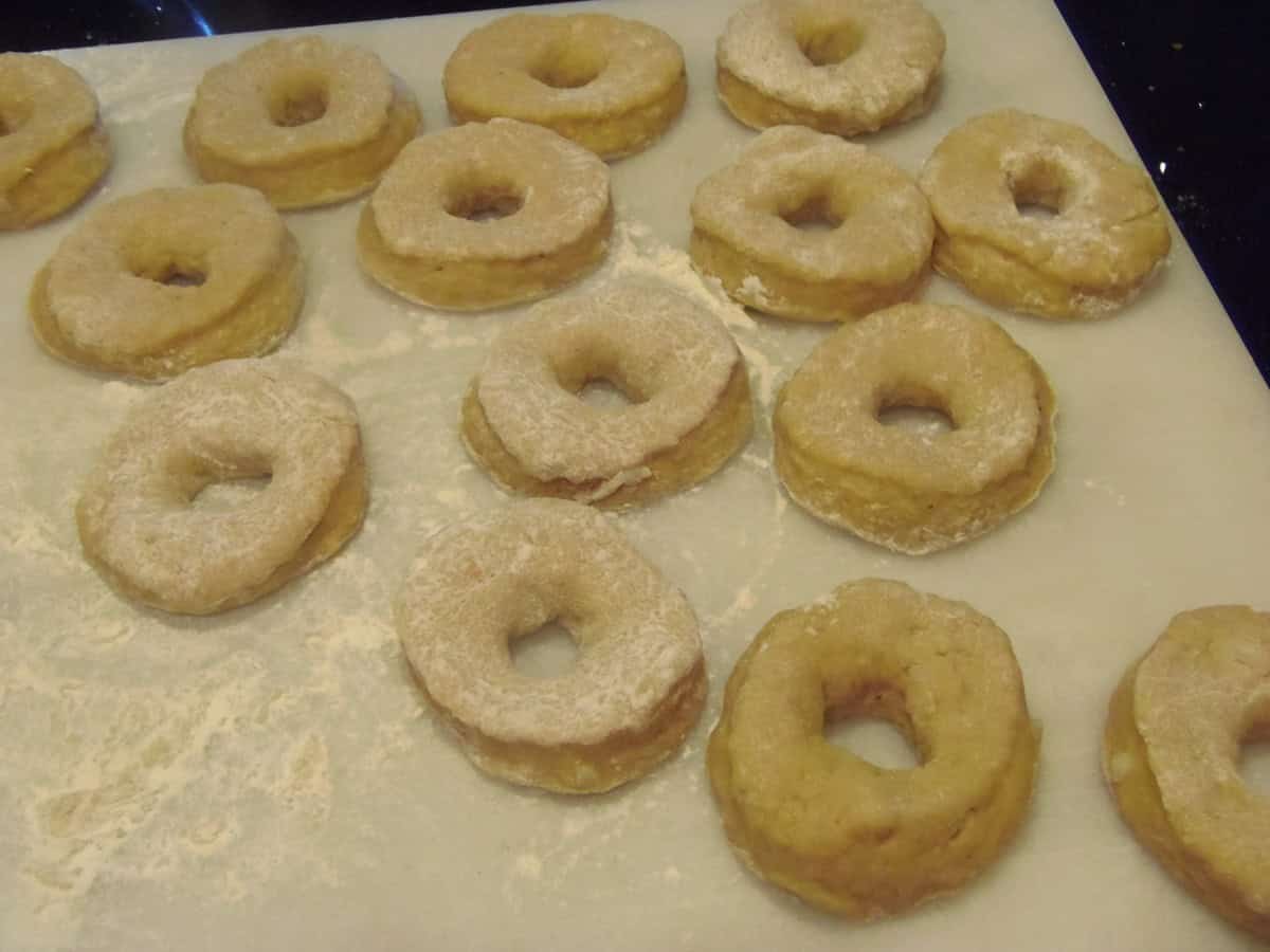 Sweet potato donuts on a floured surface before frying.