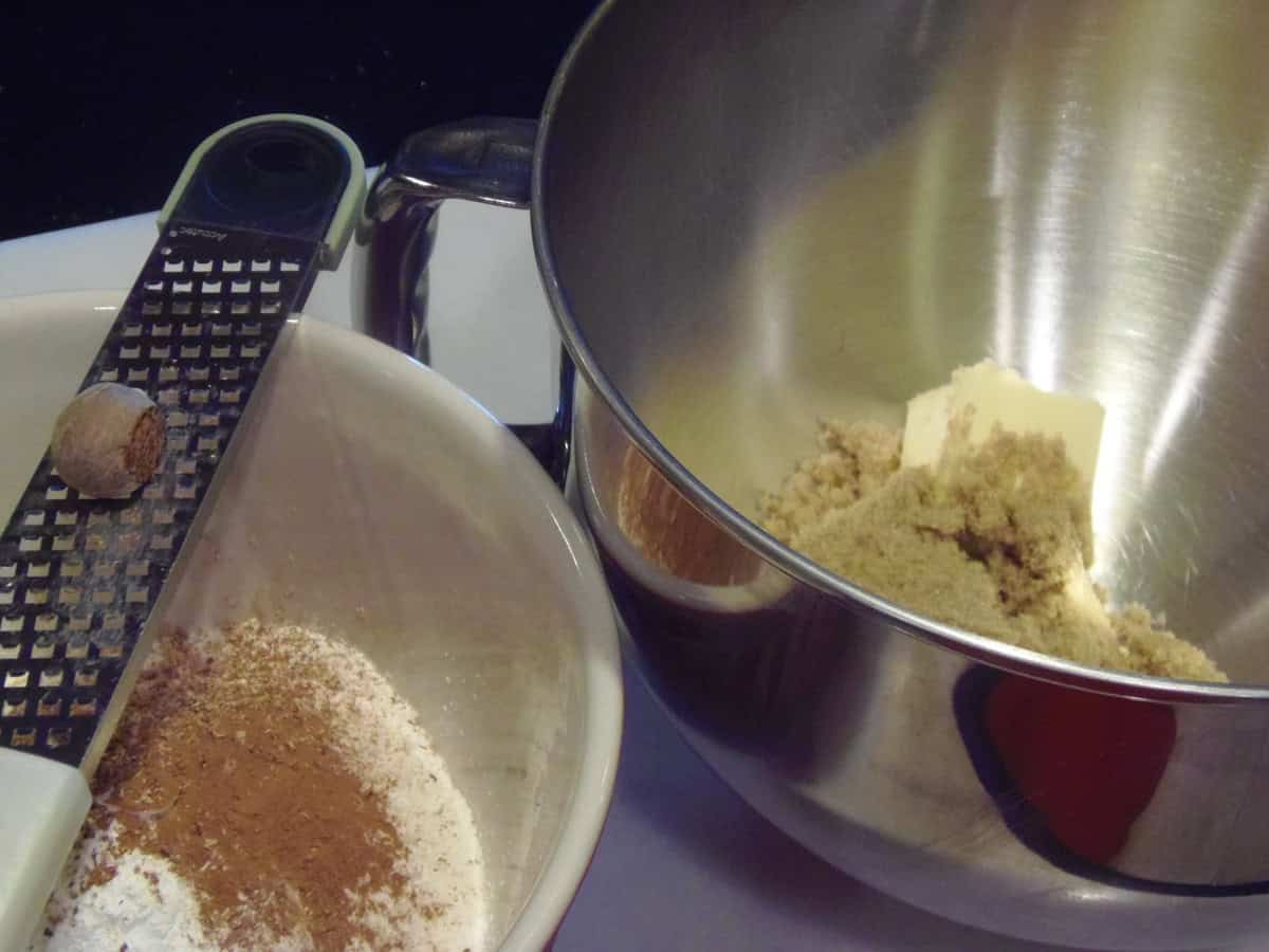 Two bowls on the counter. One with dry ingredients and one with butter and sugar.