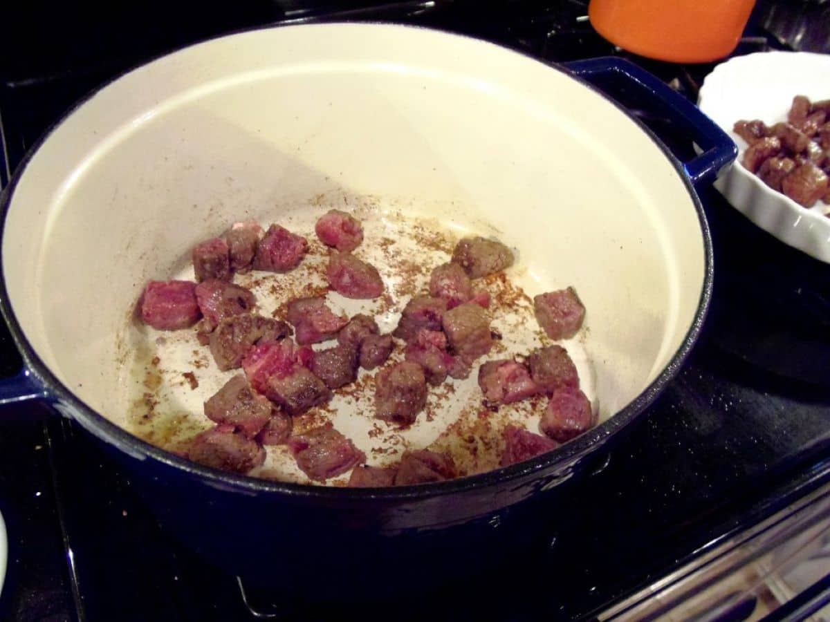 Browning beef cubes in a Dutch Oven on the stovetop.