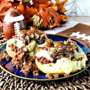 An open face French onion sloppy Joe sandwich topped with melted cheese and caramelized onions.