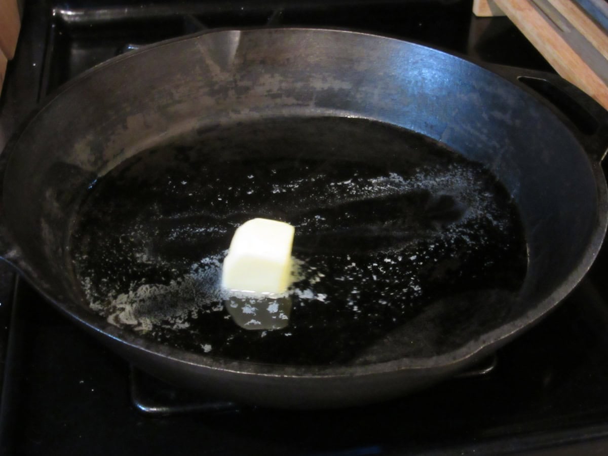 Melting butter and oil in a cast iron skillet on the stovetop.