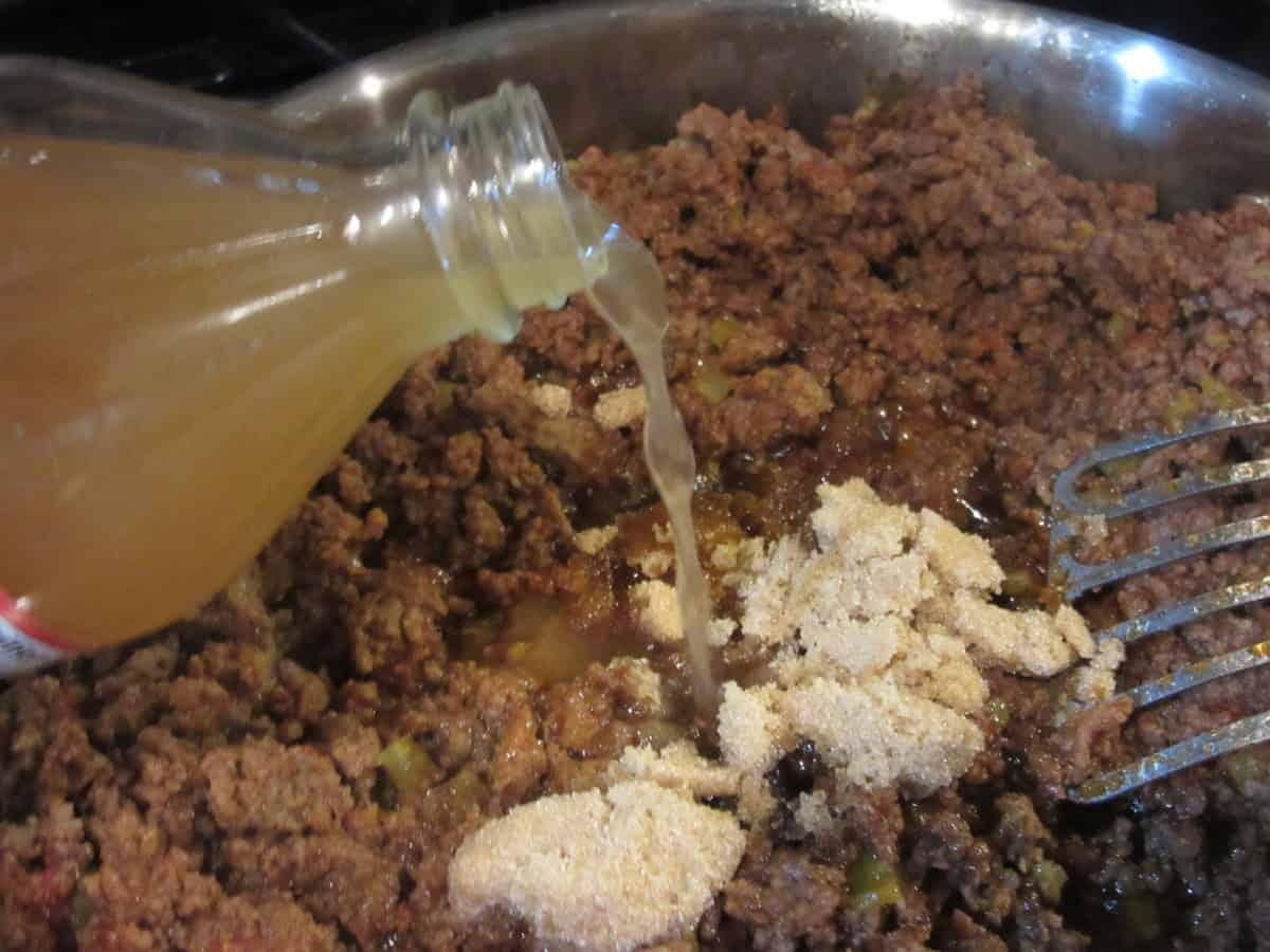 Brown sugar and apple cider vinegar added to browned ground beef in a large skillet.
