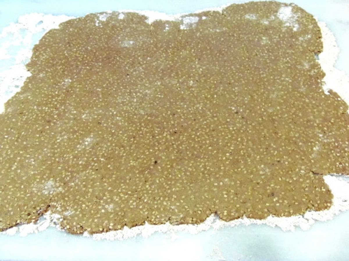 A flat, rolled sesame seed dough for making crackers before cutting.