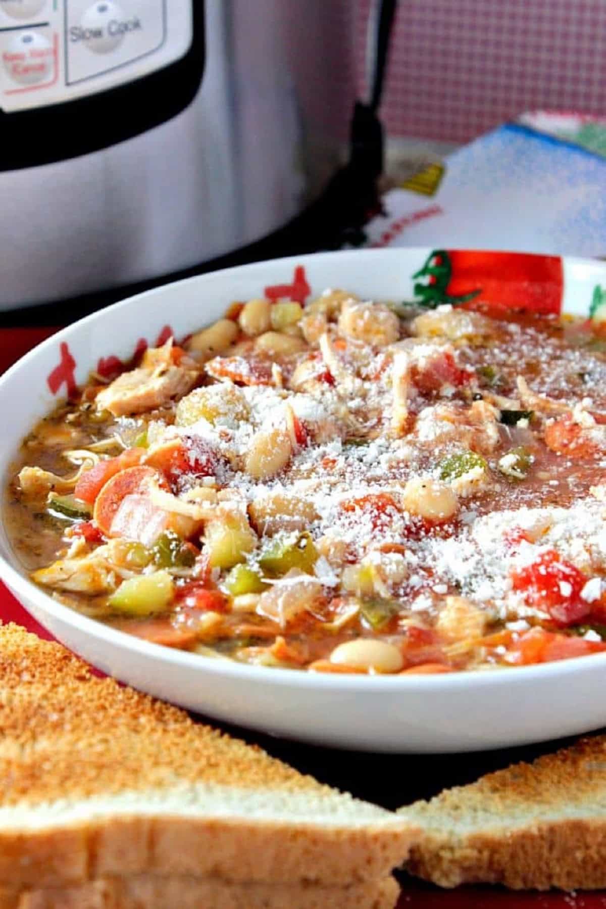 When it comes to a hearty and delicious soup that's prepared in only a matter of minutes, Italian Pepperoni Soup will be on the top of your favorite's list. | Kudos Kitchen by Renee Pasta, tomatoes, chicken, and pepperoni soup topped with grated Parm in a bowl.