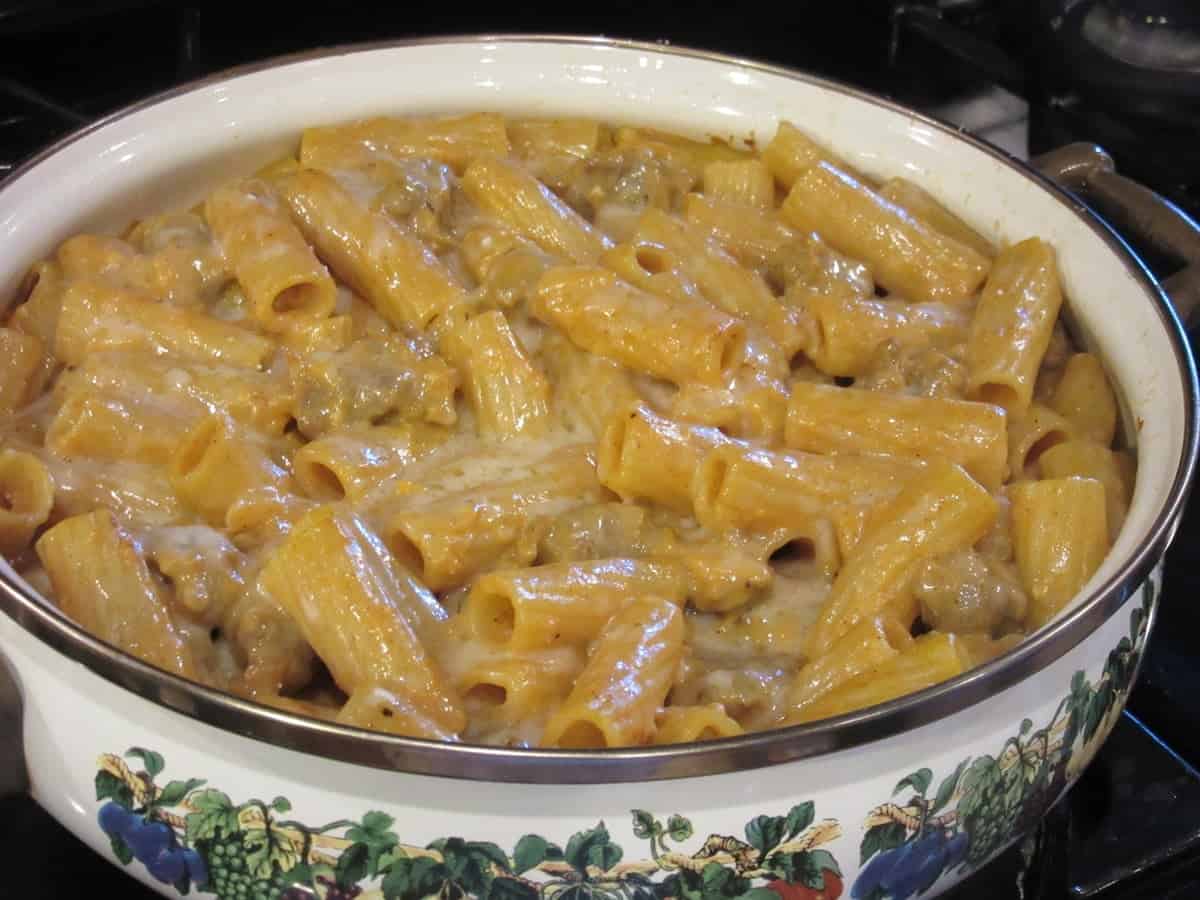 A baked rigatoni pasta covered with melted cheese in a casserole dish.